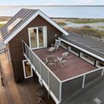 Modern villa with terrace and sea view. Wooden terrace with loungers and seating area.