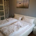 Schlafzimmer mit Doppelbett, Wandbild und Nachttisch.