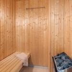 Sauna with wooden walls, bench, and stone tray