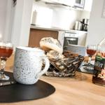 Dining table with mug, bread, and bottle on wooden surface.