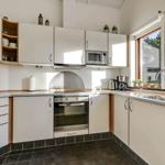 Kitchen with white cabinets, stainless steel appliances, and window with view outside.