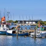 Harbor with various boats and piers under blue sky.