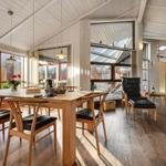 Dining room with wooden table, chairs, and view of the terrace.