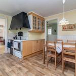 Küche mit Essbereich, Holzfußboden und hölzernem Tisch mit Stühlen.