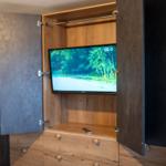 TV in integriertem Schrank mit Holzoptik und Fernbedienung