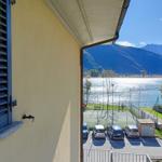 Blick von Balkon auf See und Berge mit Parkplatz und Spielplatz.