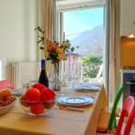 Esstisch mit Obst, Wein und Blick auf Balkon und Berge.