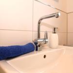 Waschbecken mit blauem Handtuch und chromfarbenem Wasserhahn