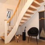 Haus mit Treppe, Stuhl, Regal und Eingangsbereich.
