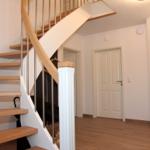 Haus mit Holztreppe und weißer Wand. Tür und Boden sind sichtbar.