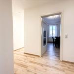 Halle mit Holzboden. Durchgang in Esszimmer mit Tisch, Stühlen und Fenster.