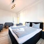 Ein Schlafzimmer mit Doppelbett, Sitzgelegenheiten und Holzboden.