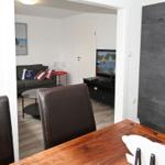 Wohnung mit Essbereich, Wohnzimmer, Fernseher und Küchenzeile.