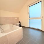 Badezimmer mit Badewanne, Toilette und großen Fenstern.