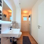 Badezimmer mit Waschbecken, Toilette, Dusche und Heizkörper.