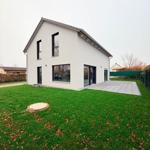 Moderne weiße Villa mit großem Garten und Terrasse.