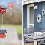 Hanging birdhouses and a table with chairs in front of a blue house.