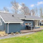 A blue house with a terrace and garden. It has an outdoor door and a table with chairs.