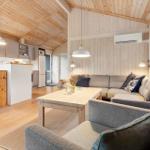 Living and kitchen area with wooden ceiling, sofa, and dining table.