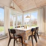 Dining room with table, chairs, and large windows to the garden