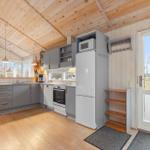 Kitchen with wooden floor, gray cabinets, and kitchen island. Passage to terrace with view of outdoor area.