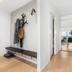 Entryway with bench, coat rack, and view into bedroom and dining area.