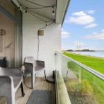 Terrace with seating and view of grassy area and harbor.