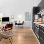 Kitchen with black cabinets and dining area with table and chairs.