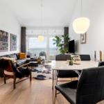 Living and dining area with sea view, sofa, dining table, and plants.