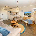 Wohnung mit Küche, Wohnbereich und Fernseher. Holzboden und moderne Einrichtung.