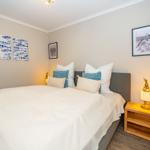 Schlafzimmer mit Bett, Nachttisch und Wandbildern