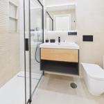 Bath with shower, sink and toilet. Wood and metal accents.