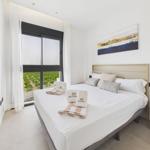 Bedroom with large bed, view of vineyard through window, and modern wall decor.