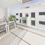 Terrace with seating area and view of modern buildings and pool area.