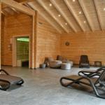 Holzvertäfelte Sauna mit Liegen und Sitzgelegenheiten.
