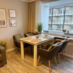 Essbereich mit Tisch, vier Stühlen und Blick auf Balkon.