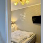 Schlafzimmer mit Bett, Wandtattoo und Wand-TV.