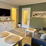 Wohnzimmer mit Sofa, Tisch und Fernseher an der Wand.