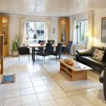 Wohn- und Essbereich mit Sofa, Tisch und Stühlen sowie Holzmöbeln.