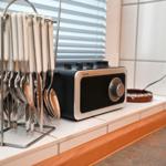 Küchenzeile mit Besteckständer und Radio auf Fliesenboden.