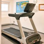 Treadmill in Fitnessraum mit Weltkarte an der Wand und Fenster