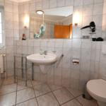 Badezimmer mit Badewanne, Waschbecken, Toilette und Spiegel.