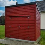 Roter Holzschuppen mit Tür und Dachrohr im Garten