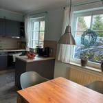 Küche mit Esstisch, Fenster und Pflanzen. Moderne Einrichtung mit Holztisch.