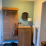 Eingangsbereich mit Kleiderschrank, Spiegel und Schrank. Holzmöbel und warmes Licht.