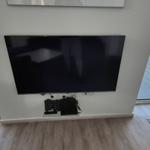 TV an der Wand, Blick auf den Hafen mit Booten.