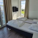 Zimmer mit Doppelbett, TV und Blick auf Hafen