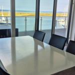 Esszimmer mit Blick auf Hafen und Meer. Tisch, Stühle und Terrasse.