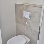 WC mit Wandmontage und Steuertaste an Steinwand