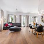 Wohn- und Essbereich mit Leder Sofa, Esstisch und Holzboden.